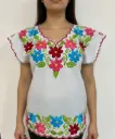 Blusa blanca con bordado de flores y los bordes morados