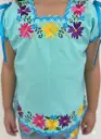 Blusa de niña menta con bordes azules y flores amarillas, rosa y morado