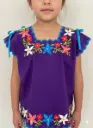 Blusa de niña morada con bordes azul y flores coral, beige y azul