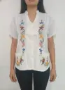 Blusa blanca abotonada con bordado de flores 
